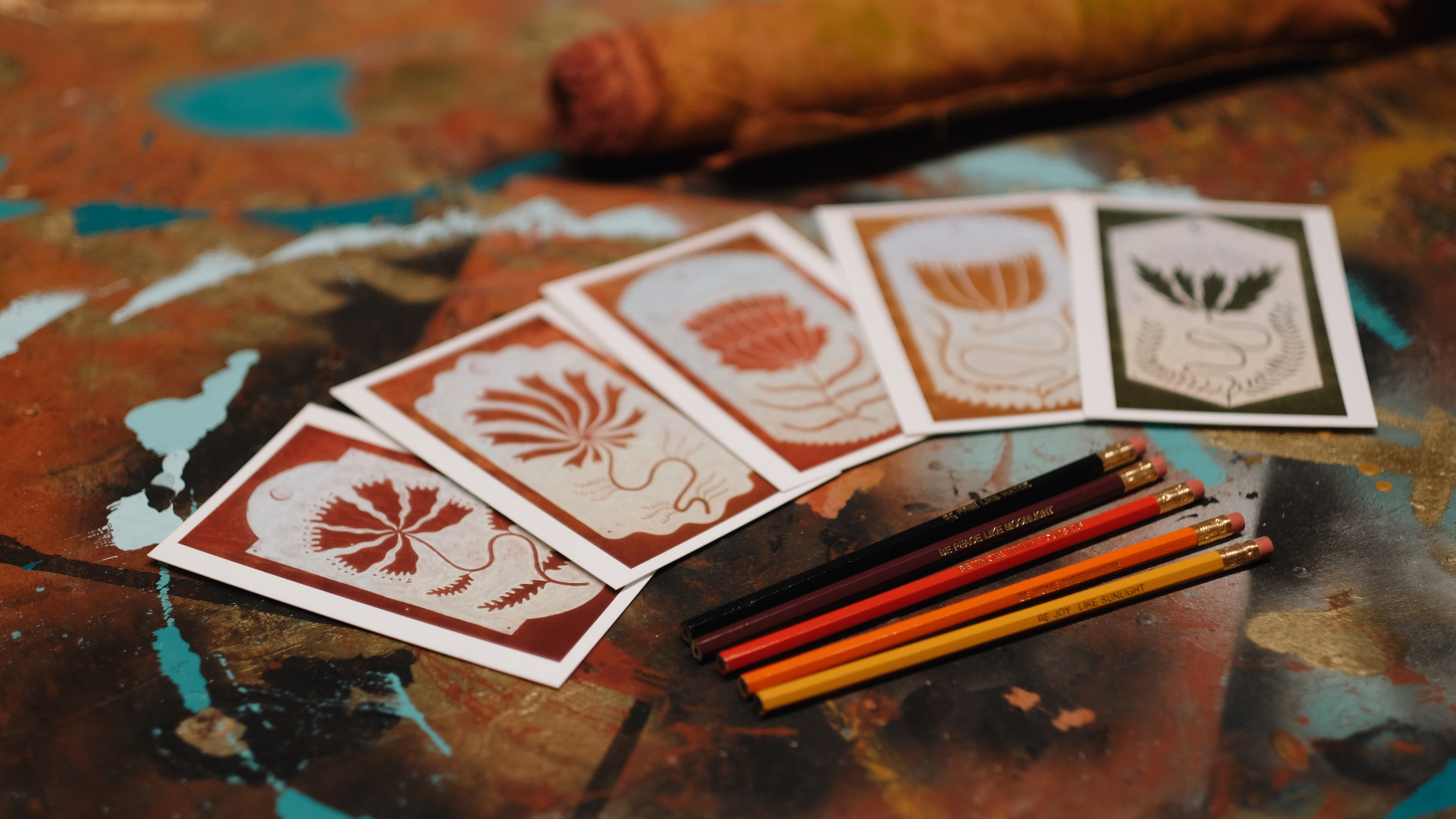 Handmade prints and pencils on a painted studio table